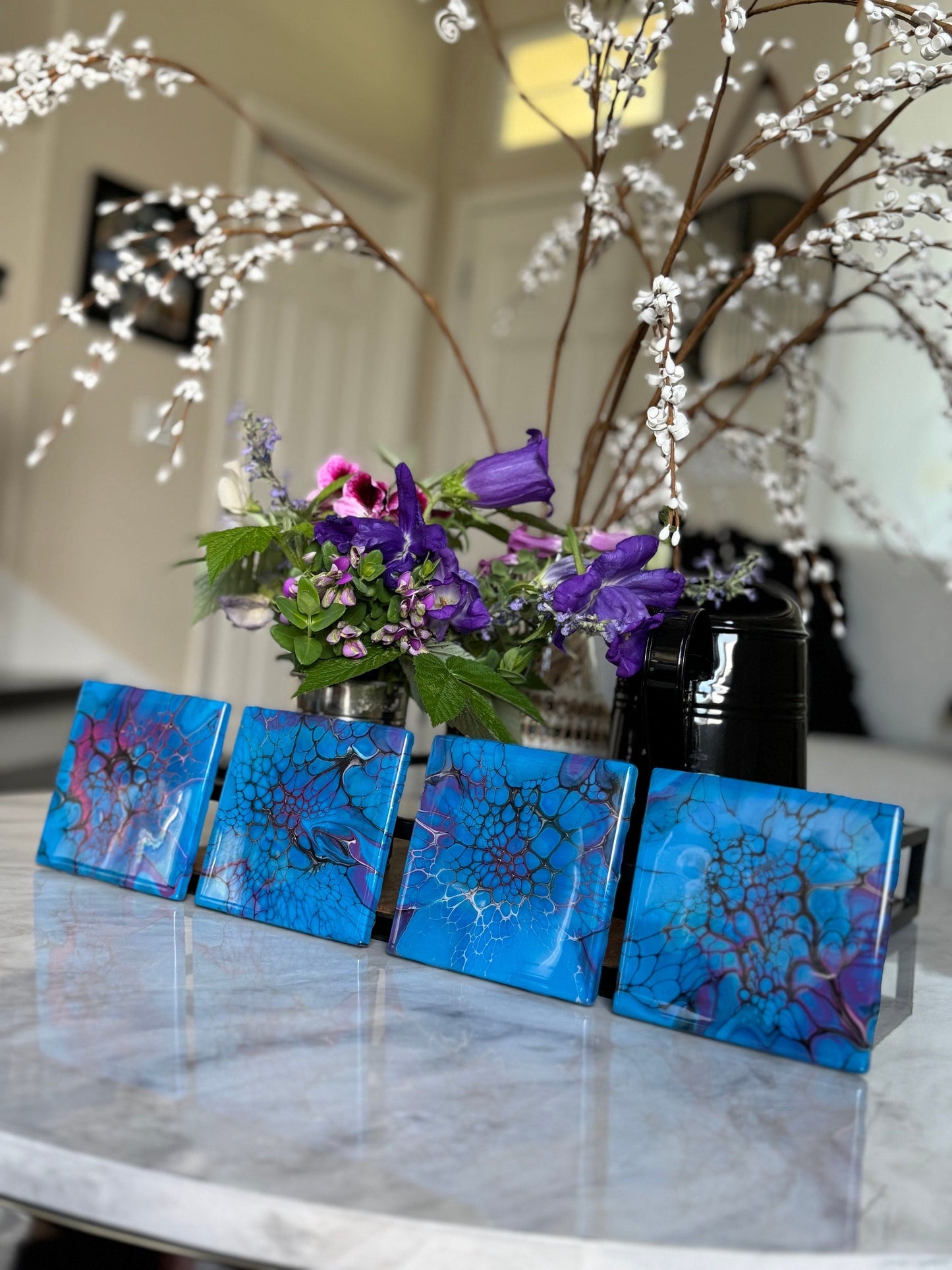 Set of four ceramic coasters in blue and pink, with shiny resin and cork backing.