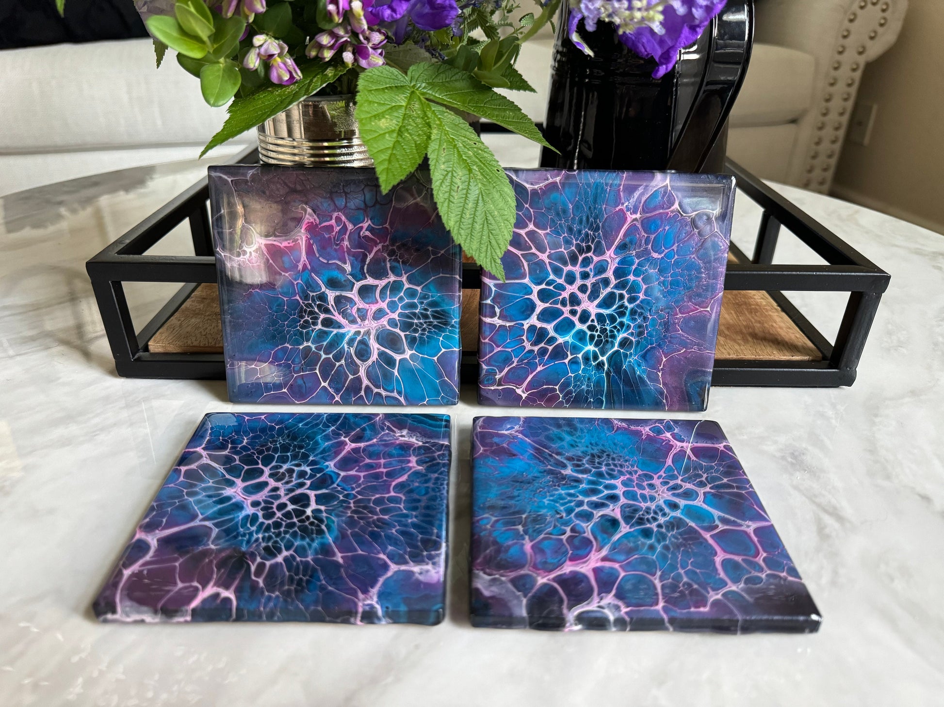 Blue and purple drink coasters with slices of pink cutting through almost like lightening bolts. These coasters are hand painted and glossy with food safe epoxy protecting them. Cork backings protect your furniture.