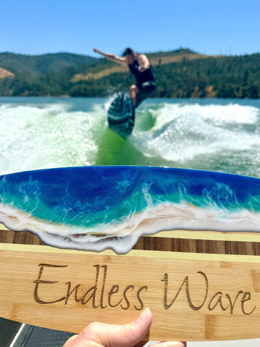 Resin Wave Wakesurf Serving Board with a wakesurfer in the background on the lake.